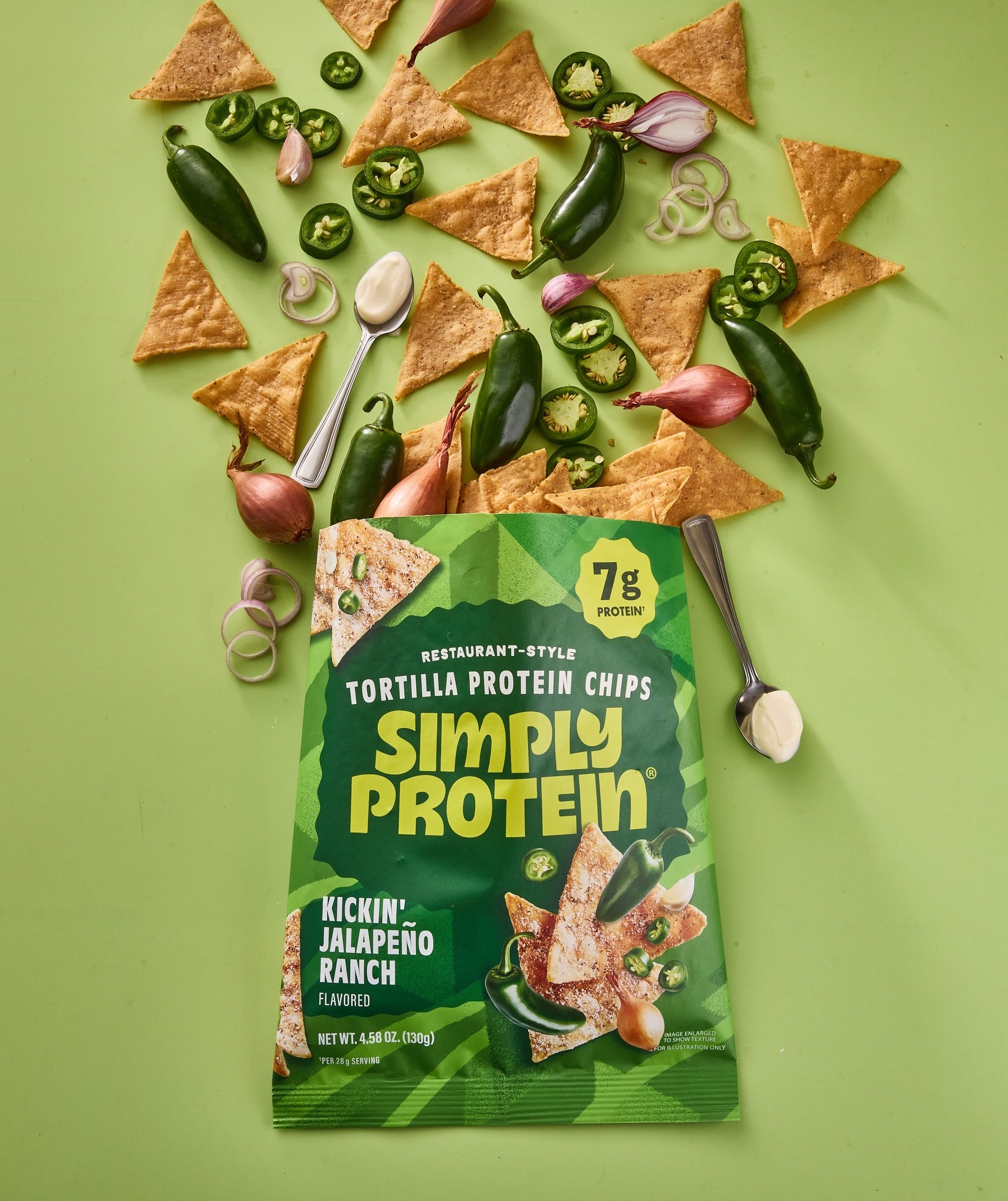 SimplyProtein tortilla protein chips packaging with jalapeño peppers and tortilla chips on a green background